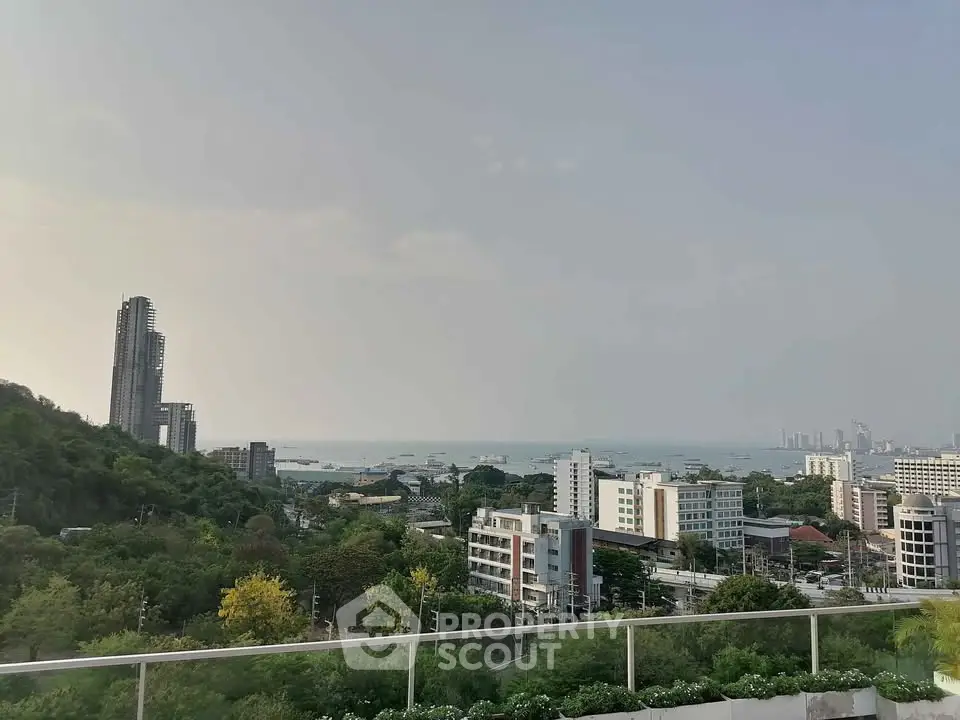 Stunning cityscape view with ocean horizon from a high vantage point, showcasing urban and natural beauty.