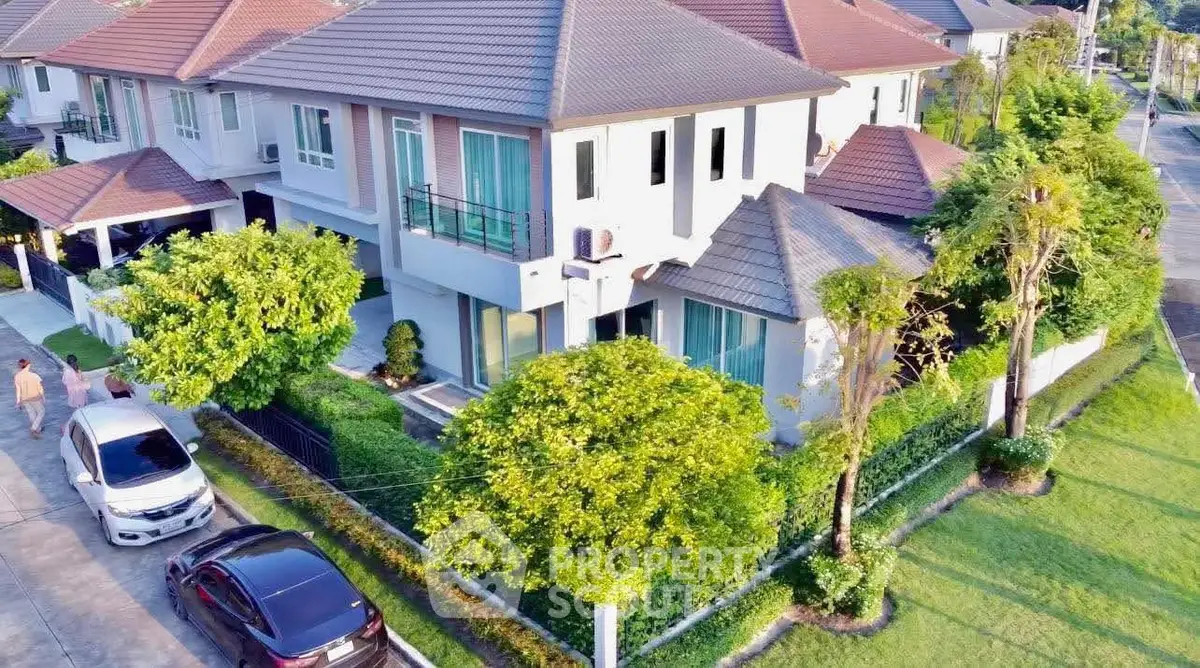 Stunning aerial view of modern two-story house with lush garden and spacious driveway.