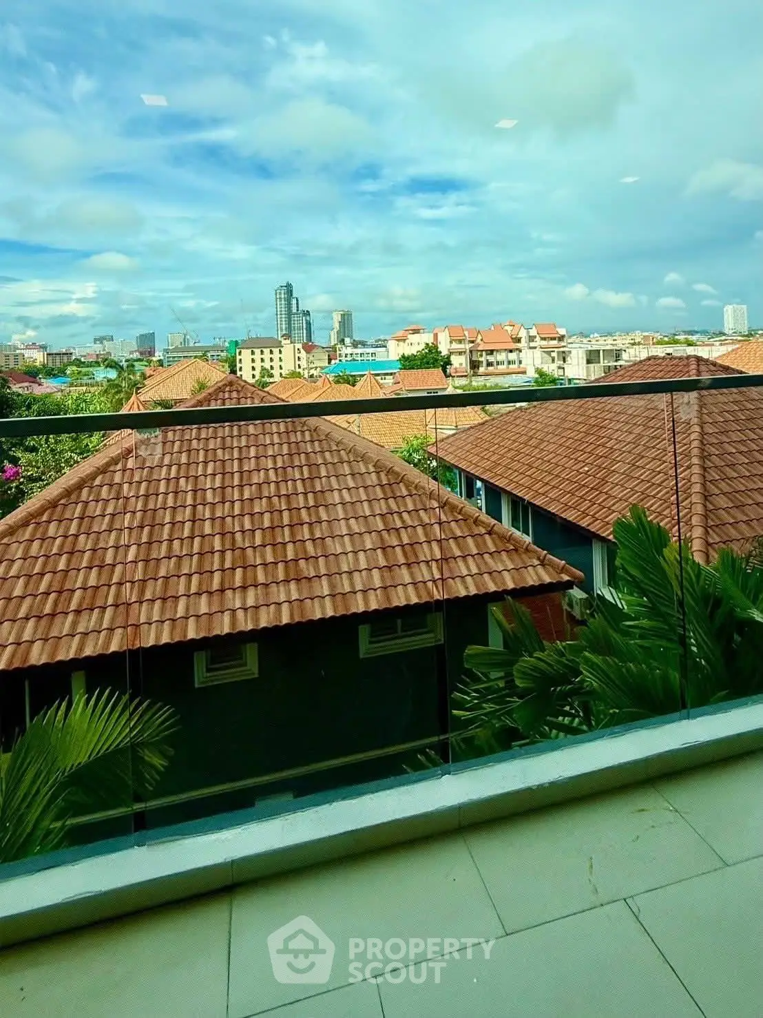 Stunning balcony view with cityscape and red-tiled rooftops, perfect for urban living.
