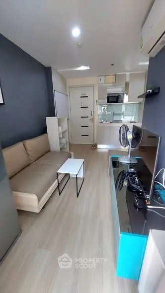 Modern living room with sleek furniture and open kitchen layout in a stylish apartment.