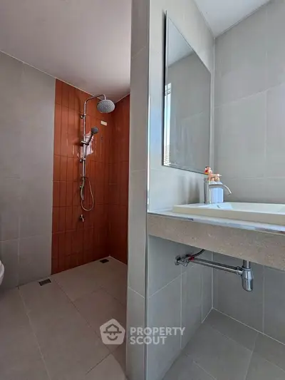 Modern bathroom with sleek shower and stylish sink in contemporary design.