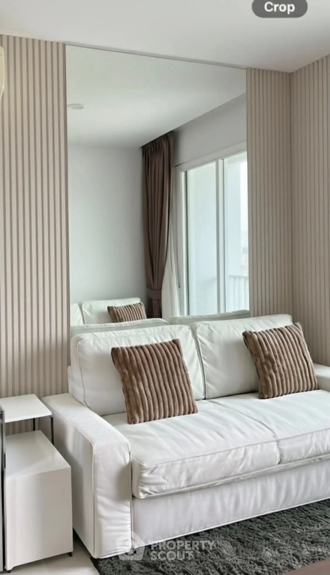 Modern living room with white sofa and large mirror, elegant decor