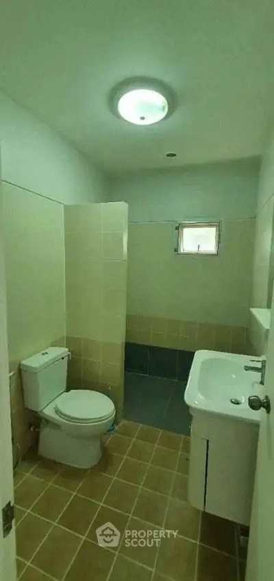 Compact bathroom with modern fixtures and tiled flooring