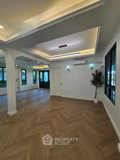 Spacious living room with elegant ceiling design and large windows
