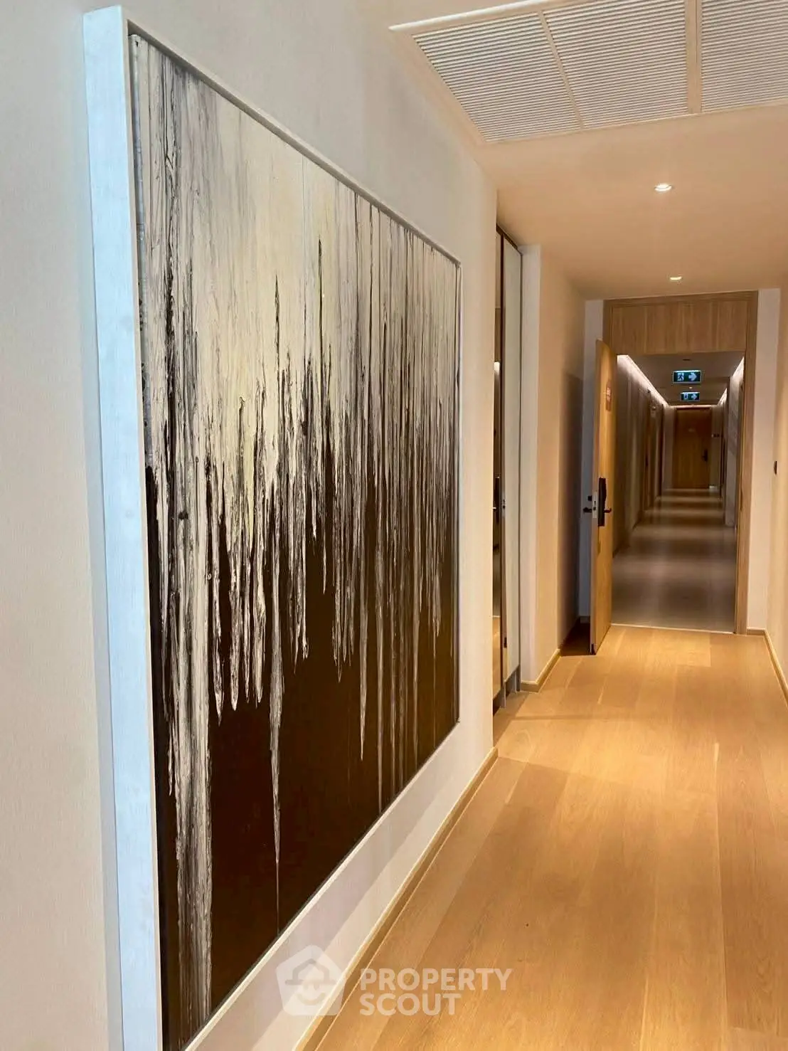 Elegant hallway with modern art and wooden flooring in upscale building