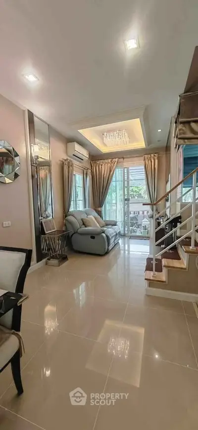 Elegant living room with modern decor and natural light, featuring a cozy sofa and stylish staircase.