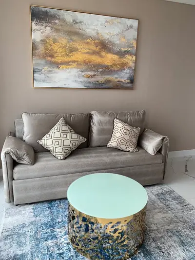 Elegant living room with modern sofa, abstract art, and stylish coffee table.