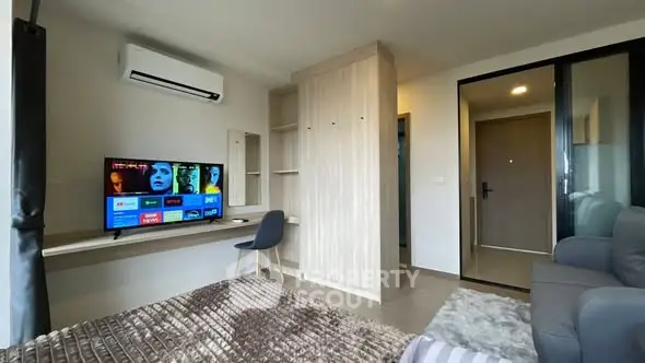 Modern living room with TV, air conditioning, and cozy decor in a stylish apartment.