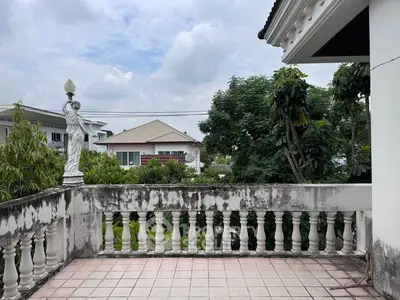 Charming balcony with classic balustrade and garden view in suburban home