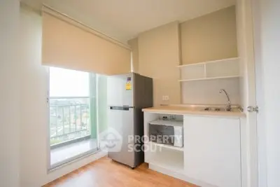 Modern kitchen with balcony view, featuring sleek appliances and ample natural light.