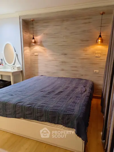 Cozy bedroom with stylish lighting and elegant vanity in modern apartment.