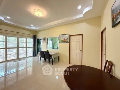 Spacious living room with elegant dining area and large windows for natural light.