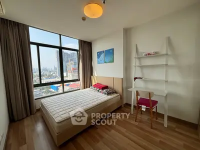Bright bedroom with city view, featuring a cozy bed and study desk, perfect for urban living.