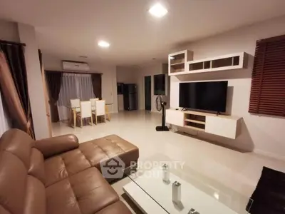Spacious modern living room with leather sofa and entertainment center
