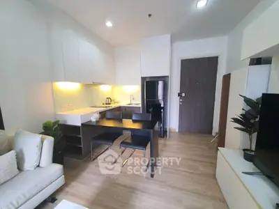 Modern open-layout kitchen with sleek cabinetry and cozy dining area in stylish apartment.