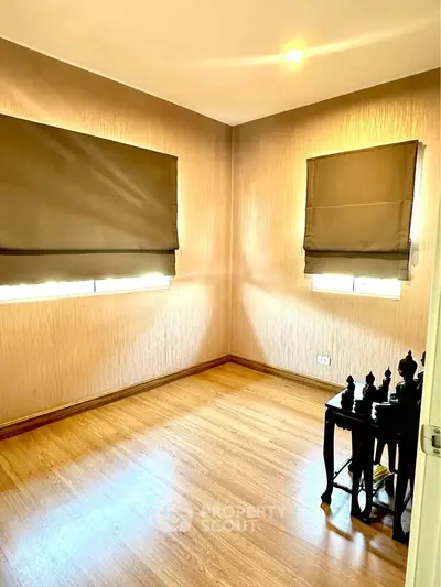 Cozy study room with wooden flooring and natural light, perfect for a home office setup.