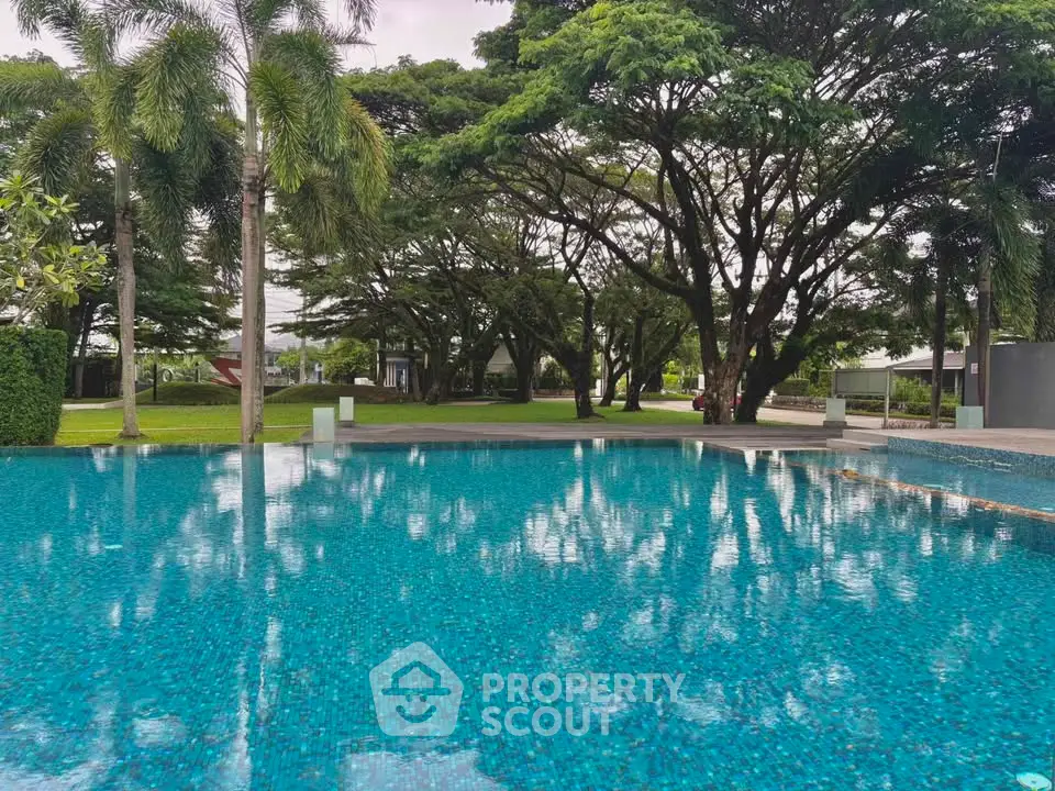 Luxurious outdoor pool with lush greenery and serene ambiance in a prime real estate location.