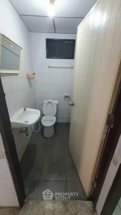 Compact bathroom with basic fixtures and tiled floor
