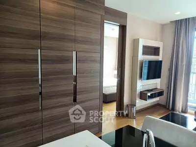 Modern apartment interior with sleek wooden cabinetry and wall-mounted TV