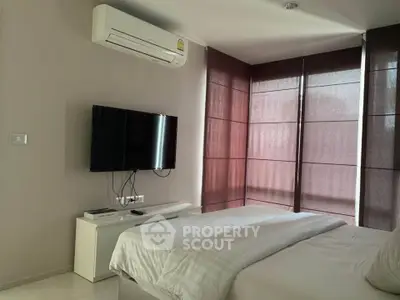 Modern bedroom with air conditioning and sleek TV setup, featuring elegant blinds and cozy bedding.