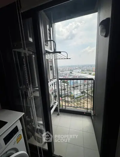 Modern apartment balcony with city view and laundry area, perfect for urban living.