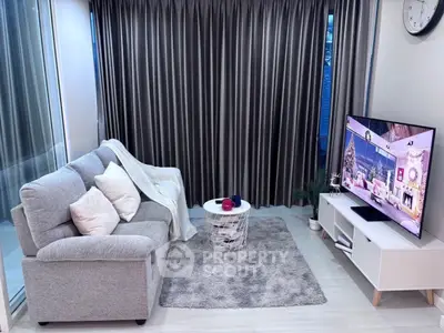 Cozy modern living room with grey sofa, stylish decor, and large TV for ultimate relaxation.