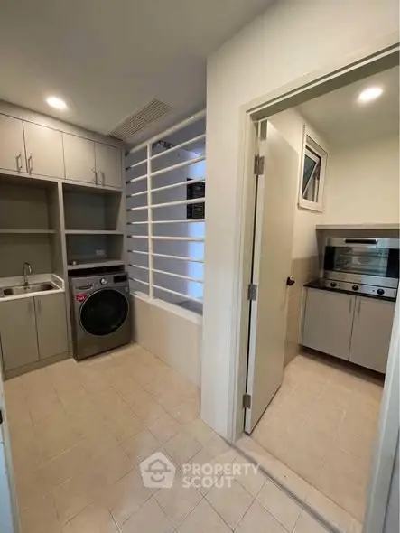 Modern laundry room with washing machine and ample storage space