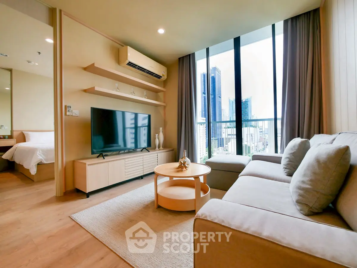 Modern living room with city view, featuring a cozy sofa and large TV, perfect for relaxation.