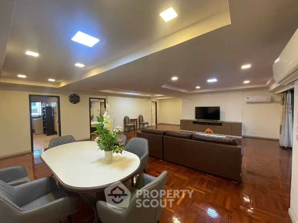 Spacious open-plan living and dining area with modern furnishings and elegant lighting.