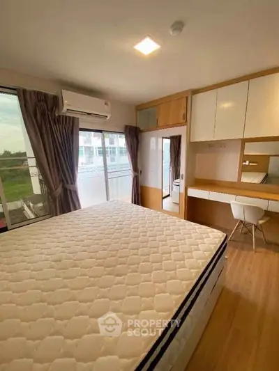 Modern bedroom with large window, built-in desk, and air conditioning in a stylish apartment.