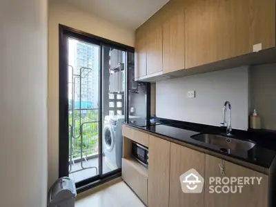 Modern kitchen with sleek cabinetry and balcony view