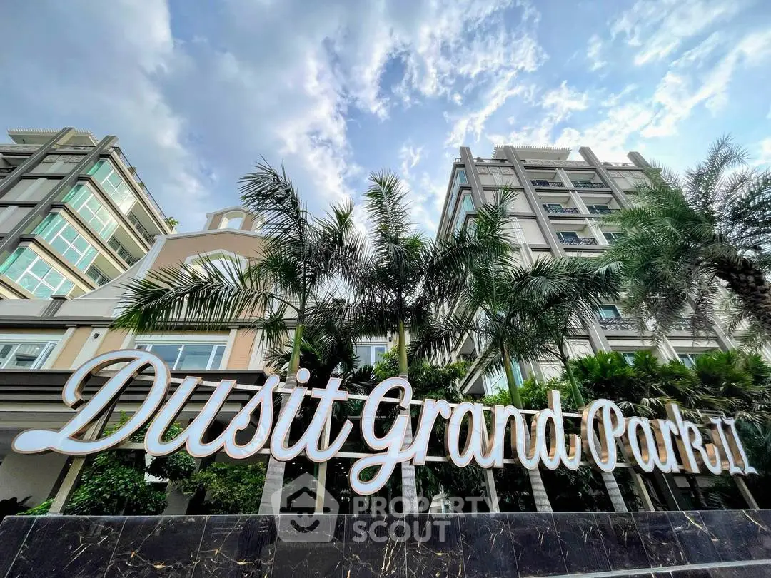Luxurious Dusit Grand Park 2 exterior with palm trees and modern architecture.