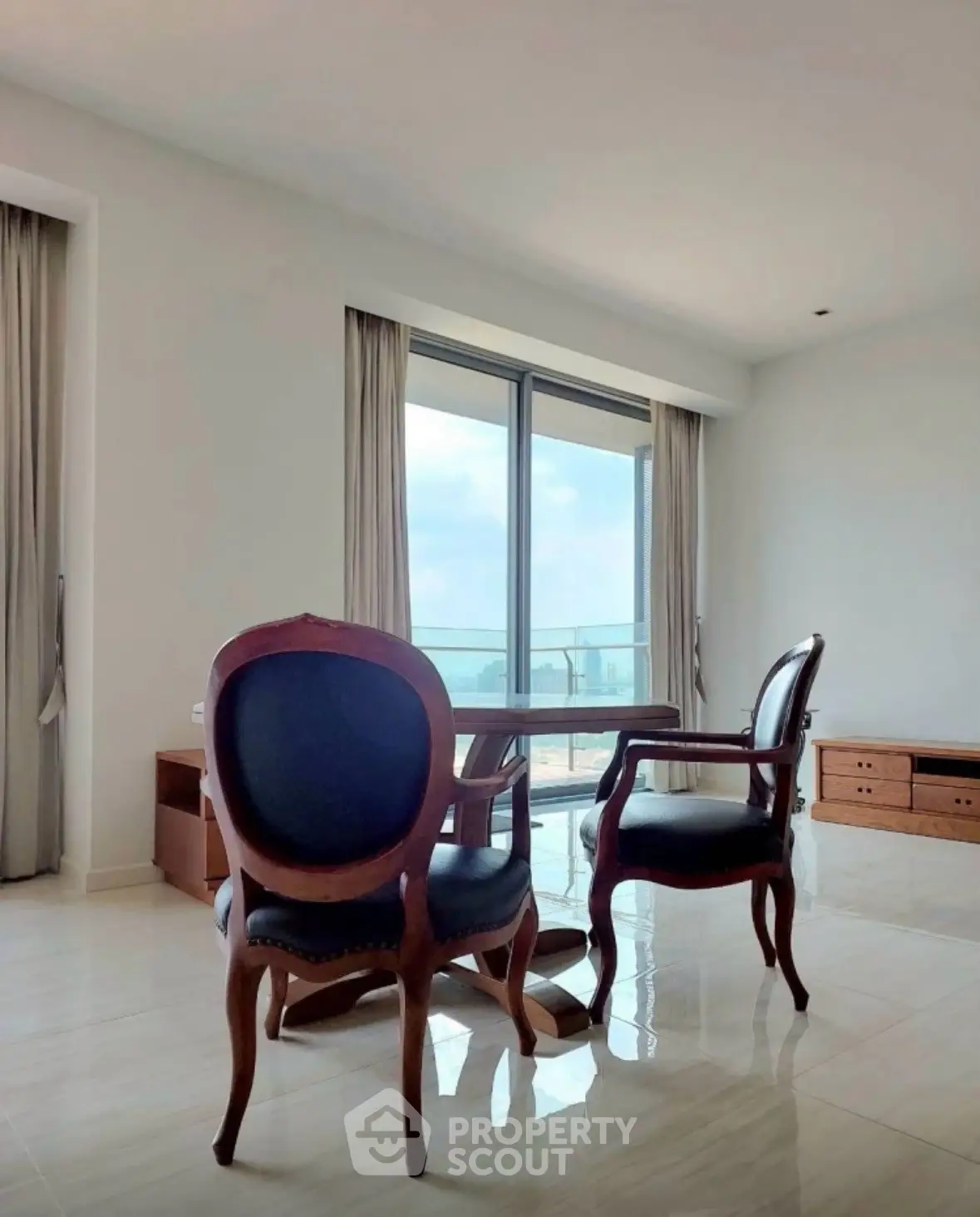 Elegant living room with classic chairs and large windows offering a stunning view.