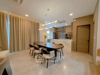 Elegant dining area with modern lighting and open kitchen layout