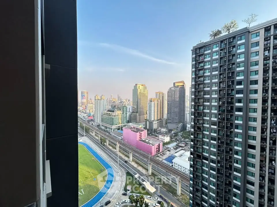 Stunning cityscape view from high-rise apartment balcony overlooking urban skyline and railway.