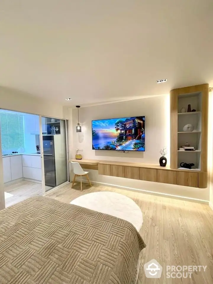 Modern bedroom with wall-mounted TV and stylish decor, featuring a cozy ambiance and sleek design.