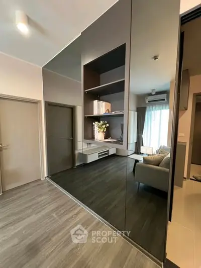Modern living room with sleek design and large mirror wall, enhancing space and light.