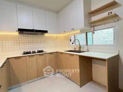 Modern kitchen with sleek cabinetry and gas stove in a bright, open layout.