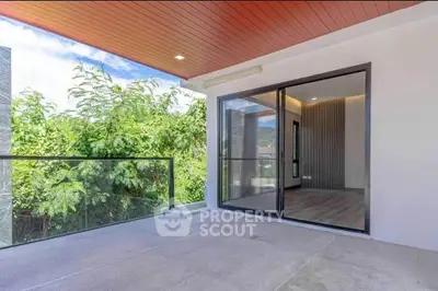 Spacious balcony with glass railing and scenic view, perfect for relaxation and outdoor enjoyment.