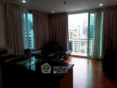 Spacious living room with city view and modern furnishings in high-rise apartment.