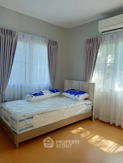Bright and airy bedroom with large windows and modern furnishings, perfect for relaxation.