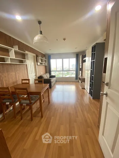 Spacious living room with wooden flooring and large window view.