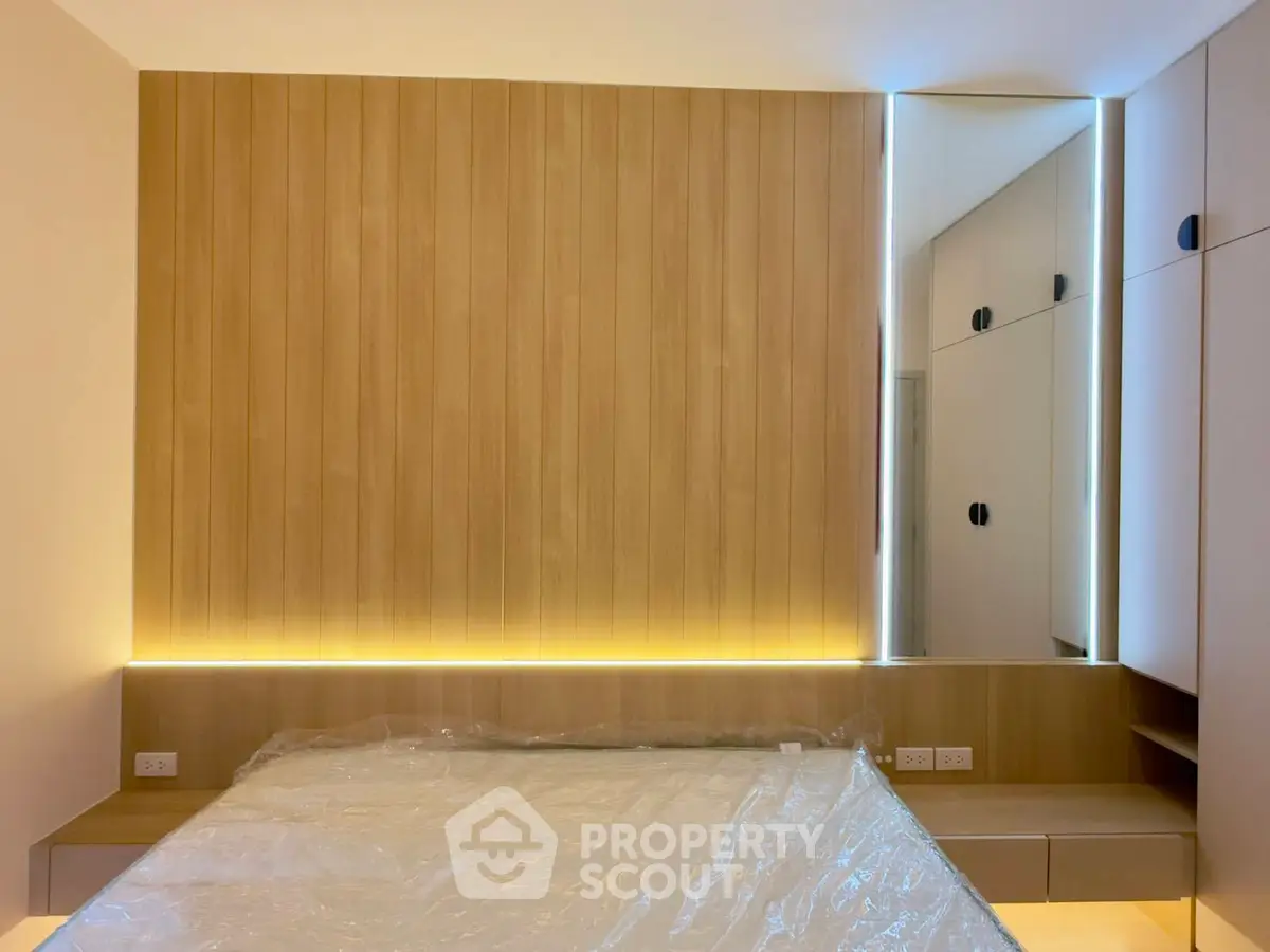 Modern bedroom with sleek wood paneling and ambient lighting