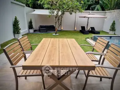 Luxurious backyard with pool, stylish patio furniture, and lush greenery for ultimate relaxation.