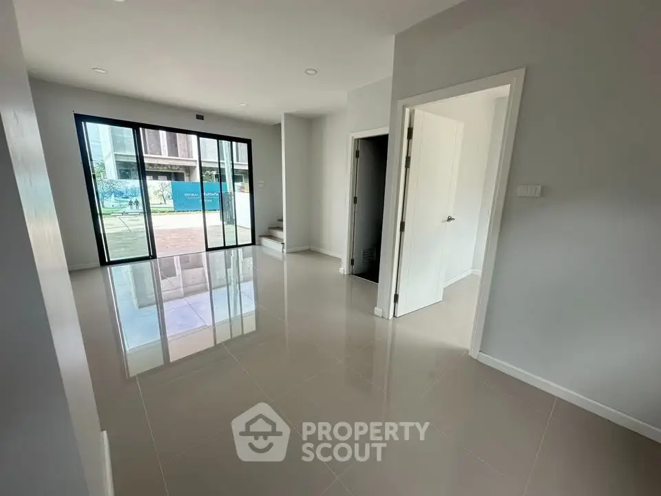 Spacious modern living room with glossy tiled floors and large windows