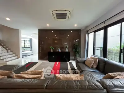 Spacious modern living room with stylish decor and large windows for natural light.