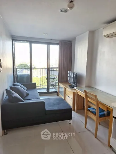 Modern living room with balcony view, featuring sleek furniture and natural light.