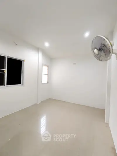 Spacious unfurnished room with tiled flooring and wall-mounted fan