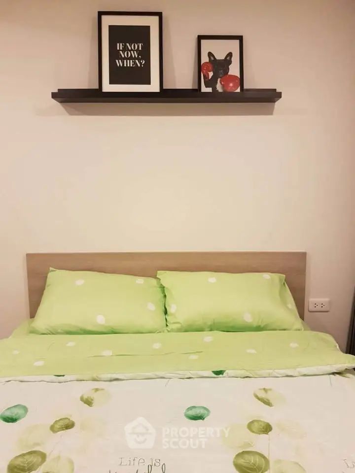 Cozy bedroom with green bedding and stylish wall art, perfect for relaxation.