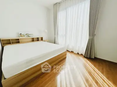 Bright and airy bedroom with large window and wooden flooring